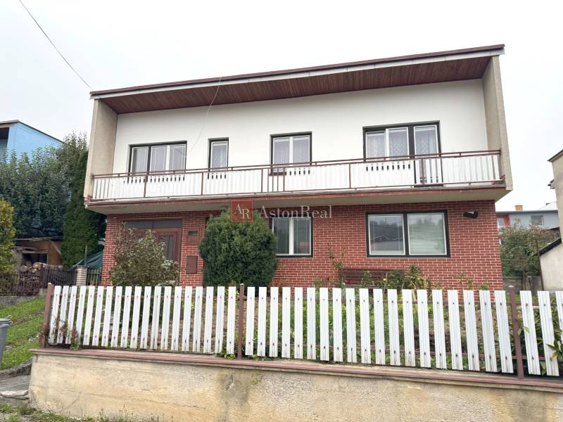 Rodinný dom na ulici Vladina v Tvrdošíne s bielym plotom a tehlovou fasádou.